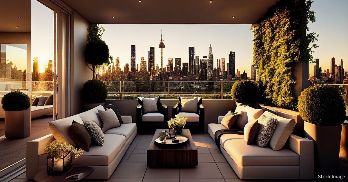 A cozy living area in the balcony of high-rise condo with city view under the sunset light.